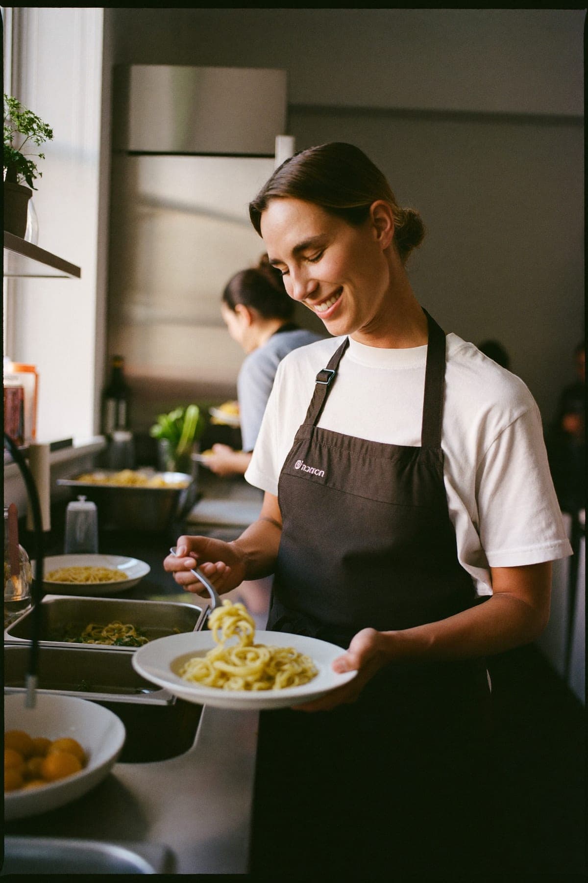 Collega in de keuken die een gerecht opmaakt